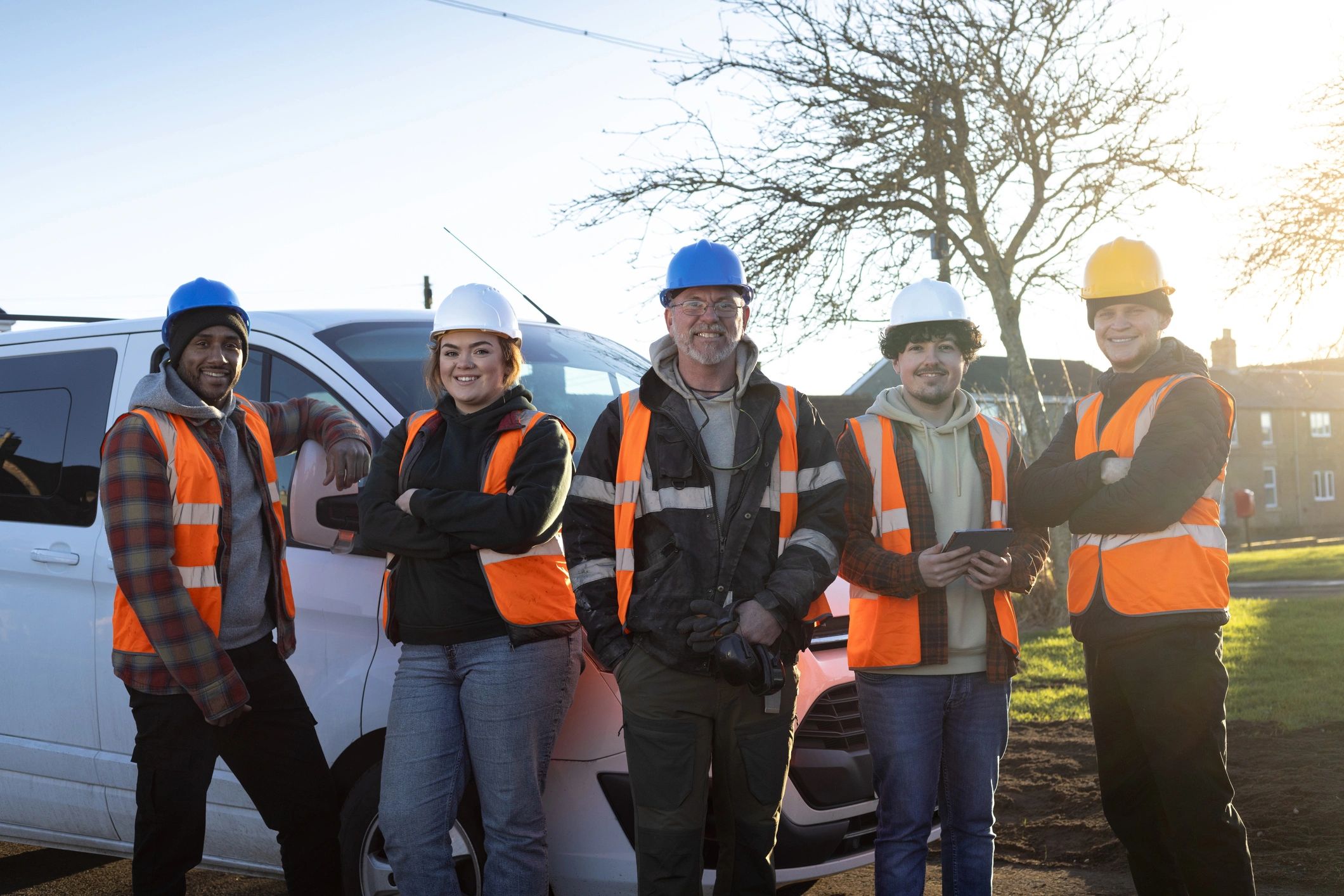 Professional service team standing together near a work vehicle